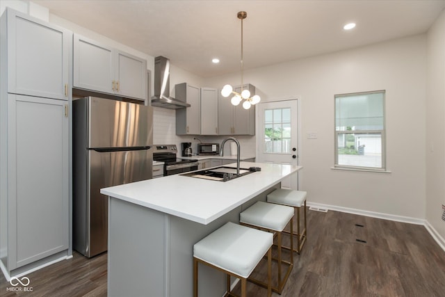 2623 Guilford Ave, Indianapolis, IN 46205 - kitchen with wall chimney range hood, appliances with stainless steel finishes, a sink, dark wood-type flooring, and an island with sink