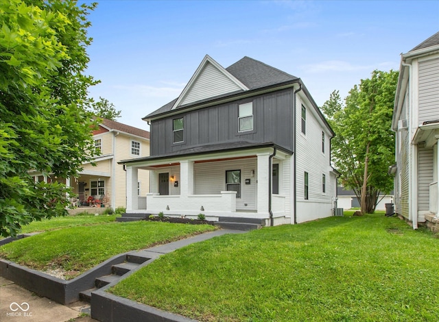 2623 Guilford Ave, Indianapolis, IN 46205 - american foursquare style home featuring board and batten siding, a porch, a front yard, and cooling unit