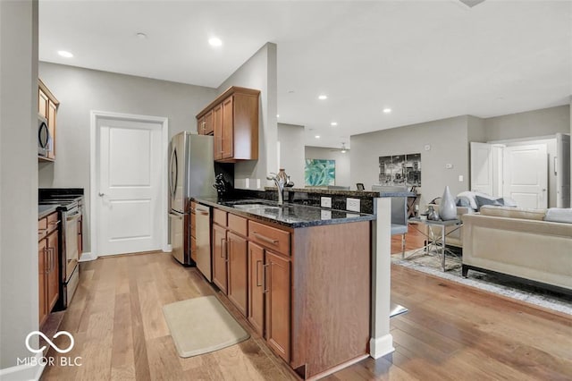 435 Virginia Ave Unit 108, Indianapolis, IN 46203 - kitchen featuring stainless steel appliances, a sink, open floor plan, light wood-style flooring, and recessed lighting