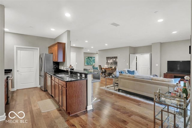 435 Virginia Ave Unit 108, Indianapolis, IN 46203 - kitchen with a sink, open floor plan, appliances with stainless steel finishes, brown cabinets, and recessed lighting
