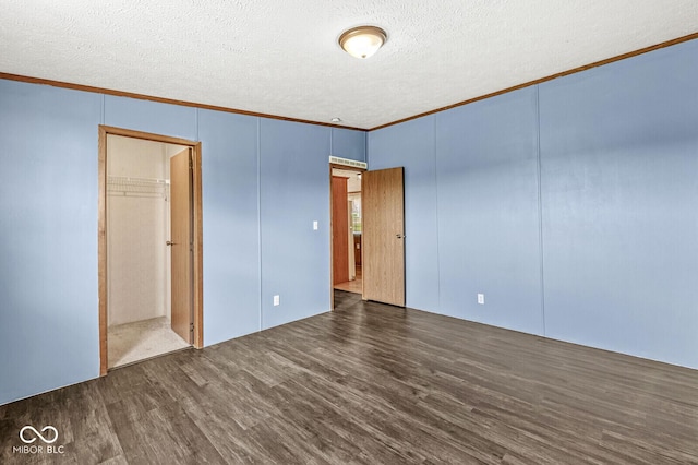 5428 S 525 W, Williamsport, IN 47993 - unfurnished bedroom featuring crown molding, wood finished floors, a textured ceiling, a decorative wall, and a closet