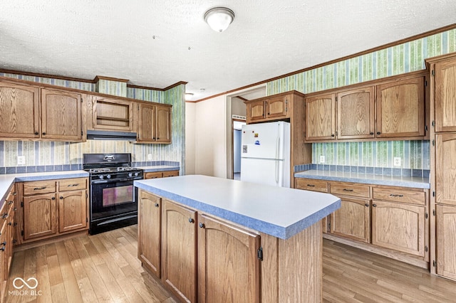 5428 S 525 W, Williamsport, IN 47993 - kitchen featuring freestanding refrigerator, black gas range, crown molding, light wood-style floors, and a kitchen island