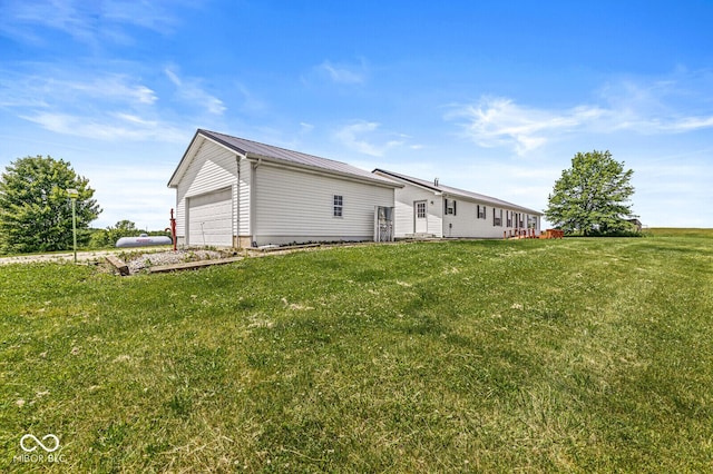 5428 S 525 W, Williamsport, IN 47993 - back of property with a yard, metal roof, and an attached garage