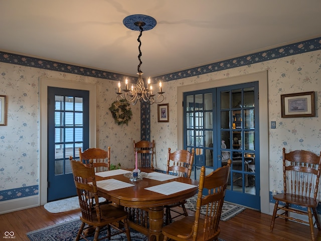 150 W Walnut St, North Vernon, IN 47265 - dining space featuring wood finished floors, a chandelier, wallpapered walls, french doors, and baseboards