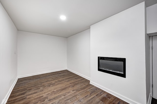 5097 Vantage Point Rd Unit B 2, Avon, IN 46123 - unfurnished living room featuring dark wood-style flooring, a glass covered fireplace, and baseboards