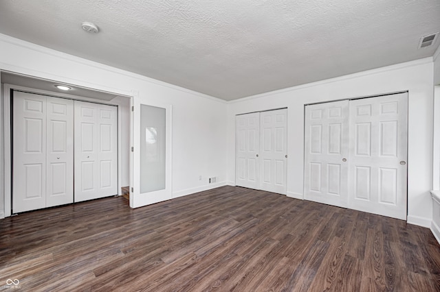 5097 Vantage Point Rd Unit B 2, Avon, IN 46123 - unfurnished bedroom with multiple closets, dark wood-style flooring, a textured ceiling, baseboards, and ornamental molding