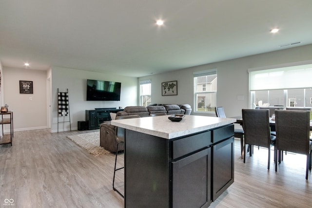 9829 Hulton Rd, Pendleton, IN 46064 - kitchen with light countertops, light wood-style flooring, a center island, recessed lighting, and a kitchen breakfast bar