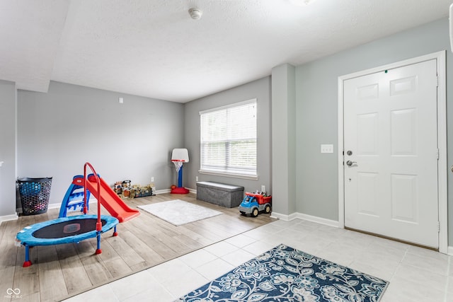 11919 Gatwick View Dr, Fishers, IN 46037 - rec room featuring a textured ceiling, baseboards, and light tile patterned flooring