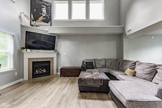 11919 Gatwick View Dr, Fishers, IN 46037 - living room with a tile fireplace, wood finished floors, and a towering ceiling