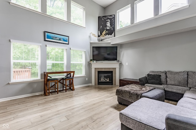 11919 Gatwick View Dr, Fishers, IN 46037 - living room with wood finished floors, a tile fireplace, plenty of natural light, and a towering ceiling