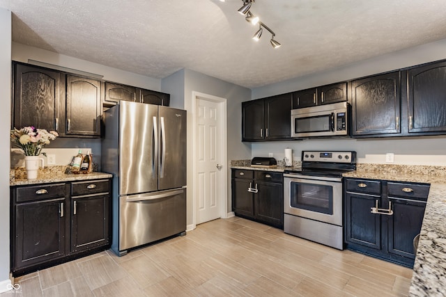 11919 Gatwick View Dr, Fishers, IN 46037 - kitchen with stainless steel appliances, wood tiled floors, light stone countertops, and a textured ceiling