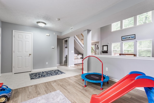 11919 Gatwick View Dr, Fishers, IN 46037 - playroom featuring wood finished floors, baseboards, and a textured ceiling