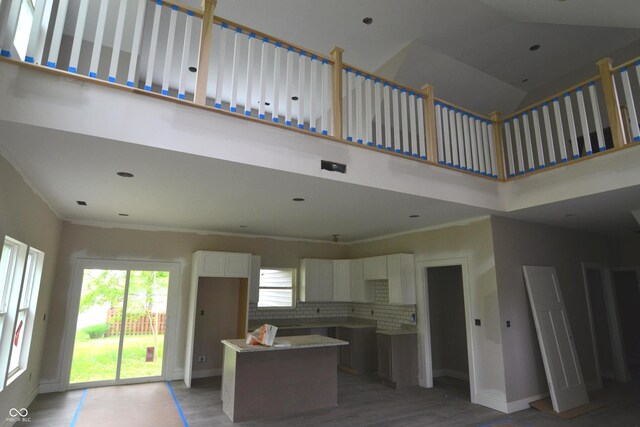 262 Jefferson Vly, Coatesville, IN 46121 - kitchen featuring a kitchen island, a high ceiling, light wood-style floors, white cabinets, and decorative backsplash