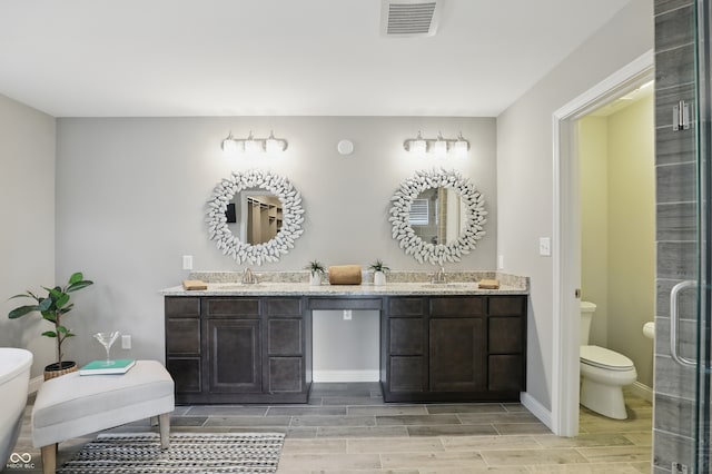 2485 Alexandra Dr, Carmel, IN 46074 - bathroom with toilet, double vanity, wood tiled floors, baseboards, and an enclosed shower