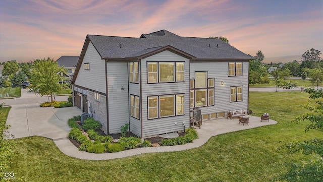 2485 Alexandra Dr, Carmel, IN 46074 - back of house with a lawn, an attached garage, a patio area, concrete driveway, and roof with shingles