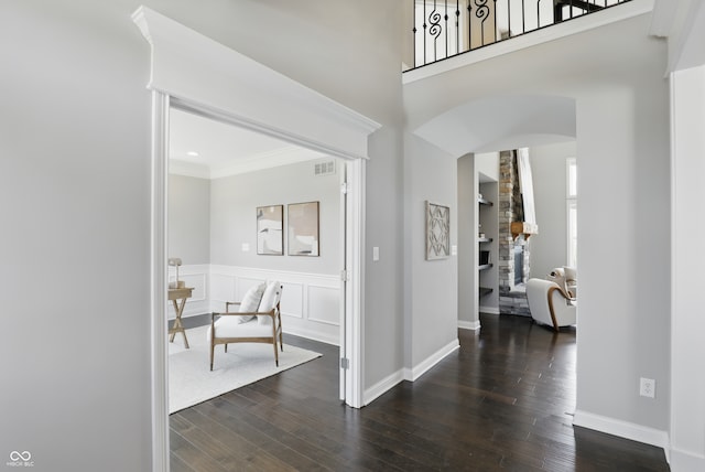 2485 Alexandra Dr, Carmel, IN 46074 - corridor featuring arched walkways, dark wood-type flooring, crown molding, wainscoting, and baseboards