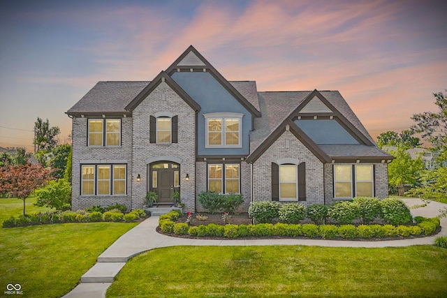 2485 Alexandra Dr, Carmel, IN 46074 - french country style house with a front lawn, stucco siding, roof with shingles, and brick siding