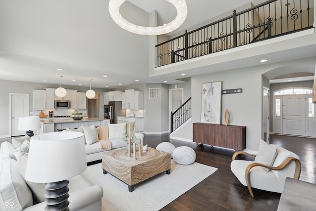 2485 Alexandra Dr, Carmel, IN 46074 - living room with baseboards, dark wood finished floors, recessed lighting, arched walkways, and stairs