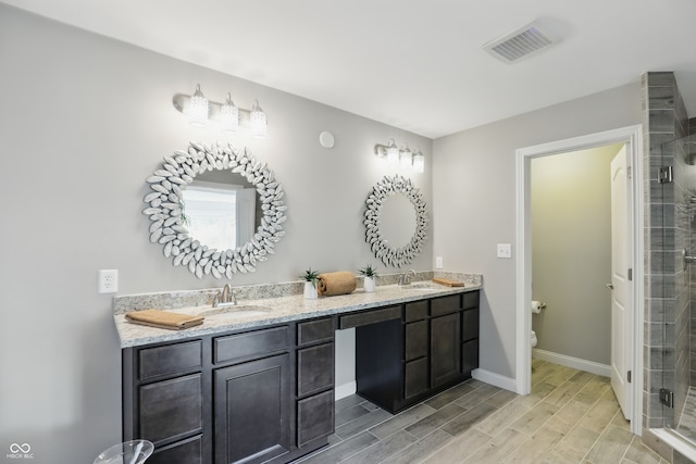 2485 Alexandra Dr, Carmel, IN 46074 - full bath with double vanity, a shower stall, toilet, wood finish floors, and baseboards
