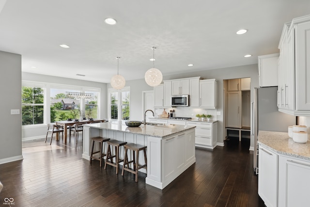 2485 Alexandra Dr, Carmel, IN 46074 - kitchen featuring stainless steel microwave, a sink, recessed lighting, an island with sink, and white cabinets
