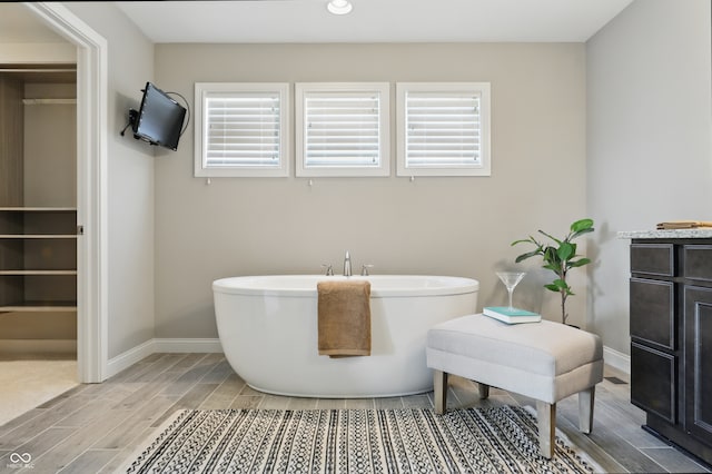 2485 Alexandra Dr, Carmel, IN 46074 - bathroom featuring wood tiled floors, a freestanding tub, baseboards, and recessed lighting