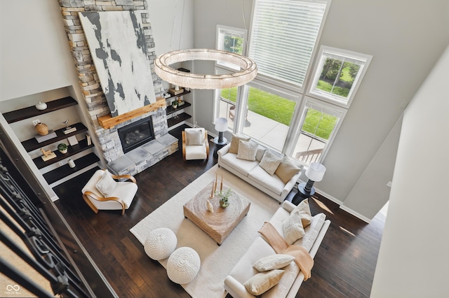2485 Alexandra Dr, Carmel, IN 46074 - living room featuring hardwood / wood-style flooring, a stone fireplace, baseboards, and a towering ceiling
