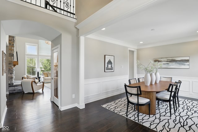 2485 Alexandra Dr, Carmel, IN 46074 - dining area featuring arched walkways, a wainscoted wall, dark wood-type flooring, recessed lighting, and ornamental molding
