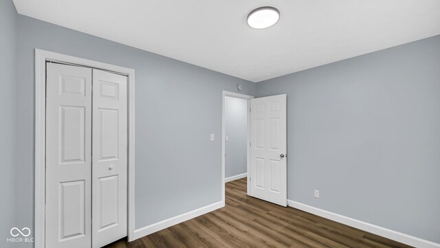 3106 N Harding St, Indianapolis, IN 46208 - unfurnished bedroom featuring baseboards, dark wood-type flooring, and a closet