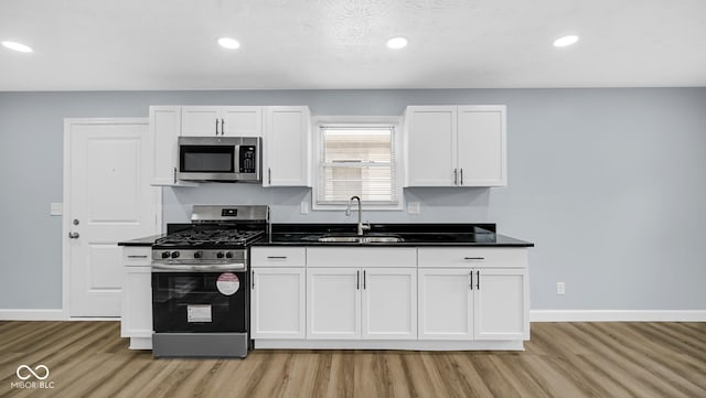 3106 N Harding St, Indianapolis, IN 46208 - kitchen featuring stainless steel appliances, a sink, light wood-type flooring, baseboards, and recessed lighting