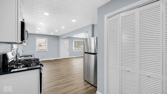 3106 N Harding St, Indianapolis, IN 46208 - kitchen featuring stainless steel appliances, a sink, baseboards, recessed lighting, and dark countertops
