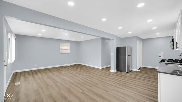 3106 N Harding St, Indianapolis, IN 46208 - unfurnished living room with light wood-type flooring, baseboards, and recessed lighting