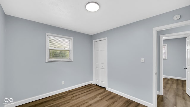 3106 N Harding St, Indianapolis, IN 46208 - unfurnished bedroom with dark wood-style flooring, baseboards, and a closet
