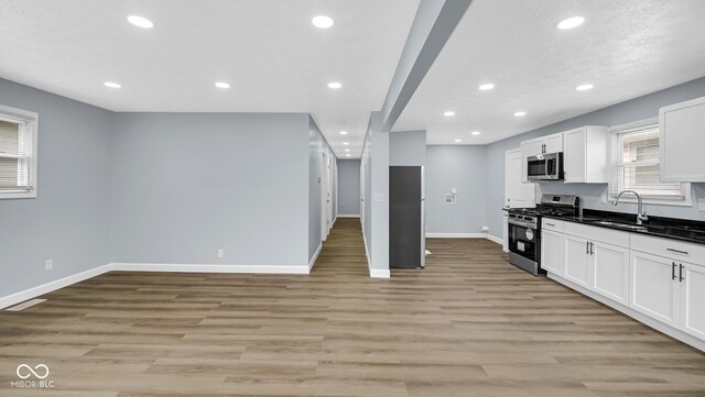 3106 N Harding St, Indianapolis, IN 46208 - kitchen featuring appliances with stainless steel finishes, recessed lighting, baseboards, dark countertops, and white cabinetry