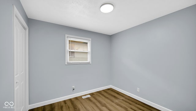 3106 N Harding St, Indianapolis, IN 46208 - unfurnished bedroom featuring dark wood-type flooring, a closet, and baseboards