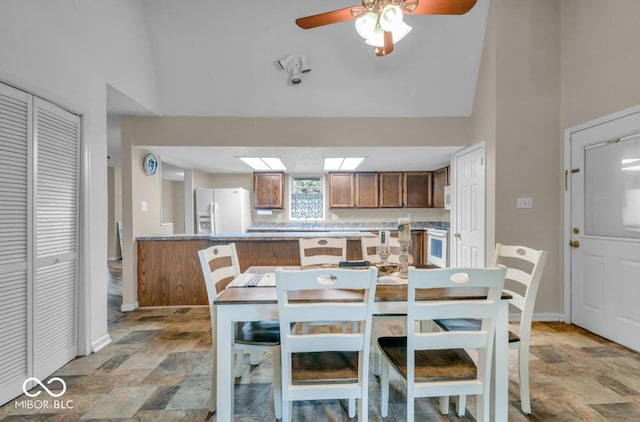 8102 Sycamore Springs Trl, Indianapolis, IN 46239 - dining space with stone finish floors, a ceiling fan, high vaulted ceiling, and baseboards