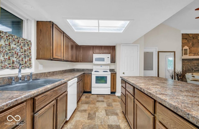 8102 Sycamore Springs Trl, Indianapolis, IN 46239 - kitchen featuring white appliances, a sink, stone finish flooring, a skylight, and brown cabinetry