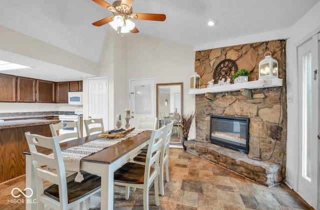 8102 Sycamore Springs Trl, Indianapolis, IN 46239 - dining area with a ceiling fan, lofted ceiling, a fireplace, and light stone finish floors