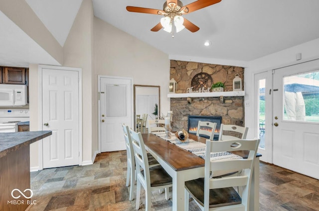 8102 Sycamore Springs Trl, Indianapolis, IN 46239 - dining space with stone finish flooring, vaulted ceiling, a ceiling fan, a fireplace, and baseboards