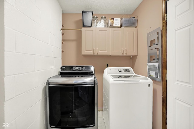 9002 Walton St, Indianapolis, IN 46231 - washroom featuring cabinet space, independent washer and dryer, light tile patterned floors, and a textured ceiling