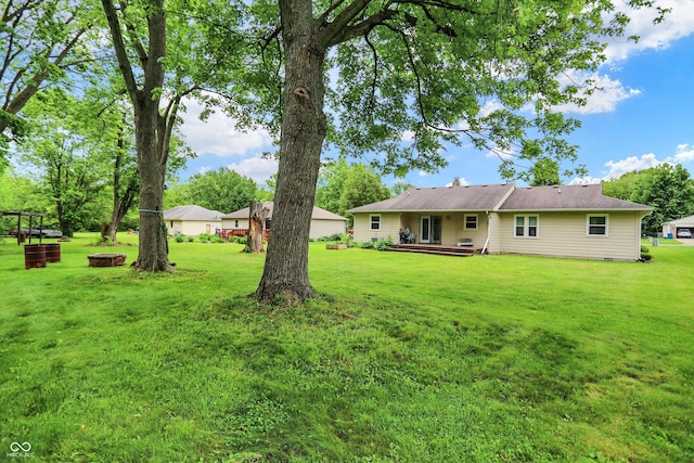 9002 Walton St, Indianapolis, IN 46231 - view of green lawn featuring a wooden deck and an outdoor fire pit