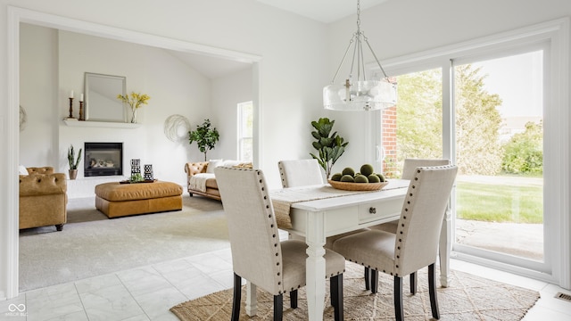 734 Richland Way, Westfield, IN 46074 - dining area featuring a chandelier, healthy amount of natural light, vaulted ceiling, a glass covered fireplace, and light marble finish flooring