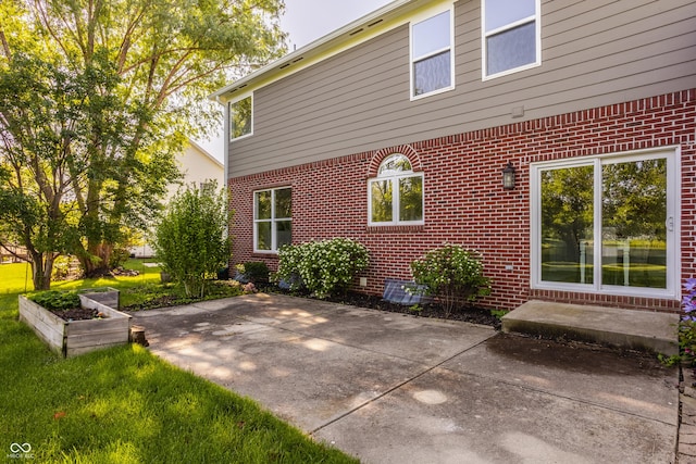 734 Richland Way, Westfield, IN 46074 - view of side of property featuring brick siding, a patio area, and a garden