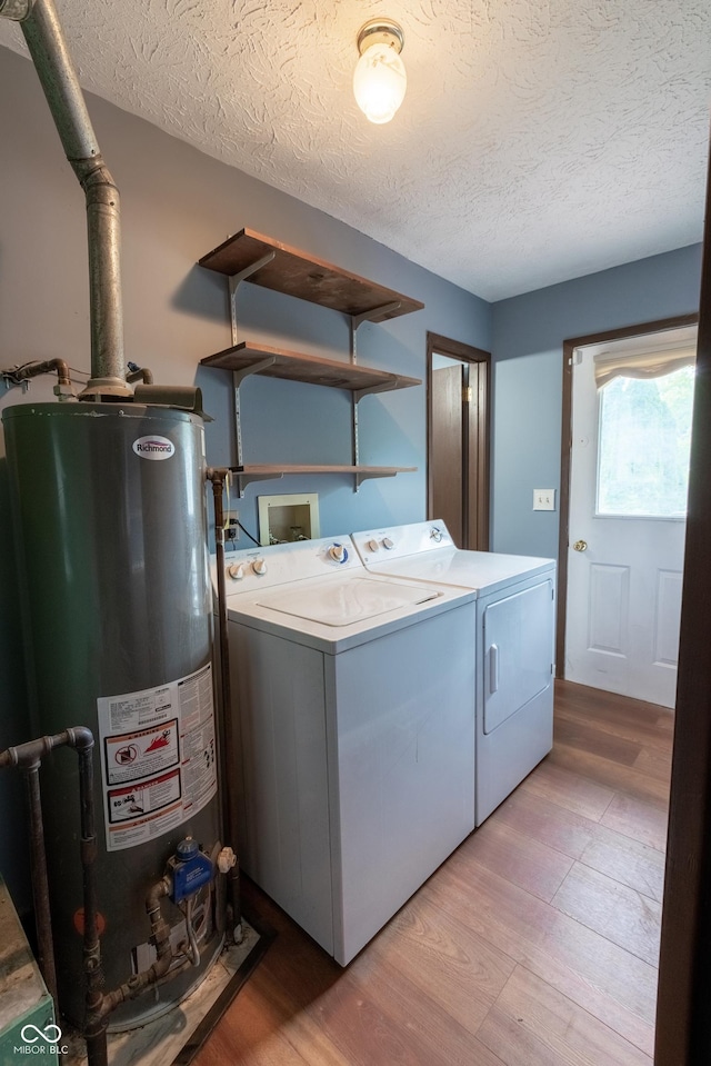 1708 Mason Dixon Dr S, West Lafayette, IN 47906 - laundry area featuring washer and clothes dryer, water heater, light wood-style flooring, and a textured ceiling