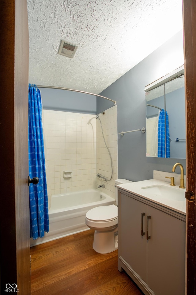 1708 Mason Dixon Dr S, West Lafayette, IN 47906 - full bathroom featuring vanity, shower / bath combo with shower curtain, a textured ceiling, toilet, and wood finished floors