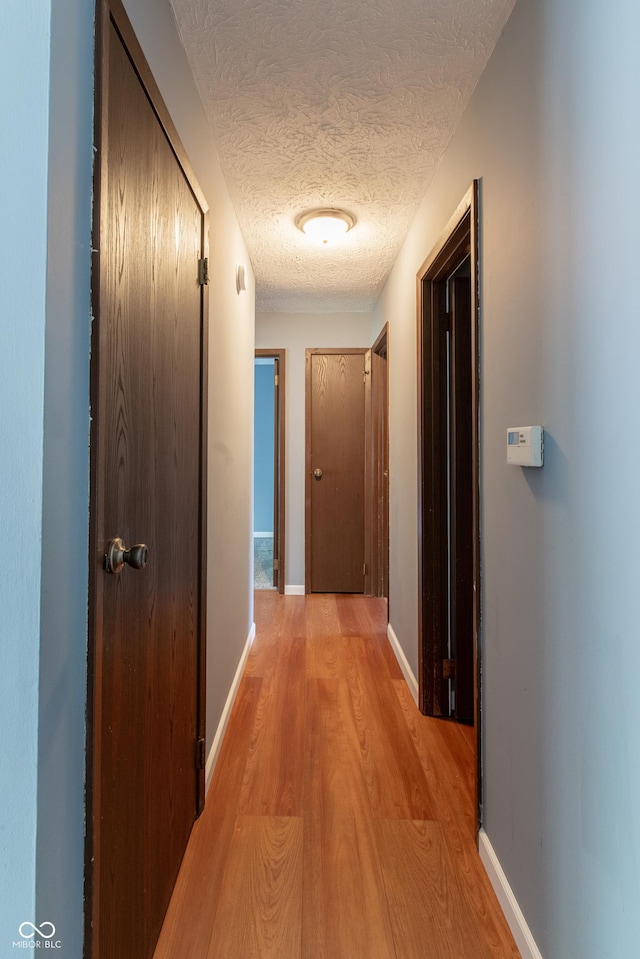 1708 Mason Dixon Dr S, West Lafayette, IN 47906 - hallway featuring light wood-style floors, a textured ceiling, and baseboards