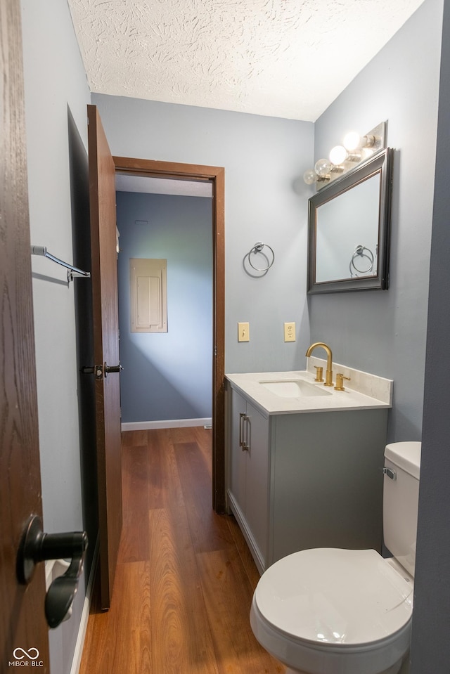 1708 Mason Dixon Dr S, West Lafayette, IN 47906 - half bathroom featuring wood finished floors, toilet, vanity, a textured ceiling, and baseboards