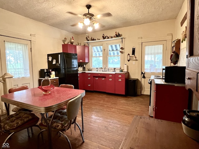 5855 S County Road 800 E, Coatesville, IN 46121 - kitchen with red cabinets, black appliances, a textured ceiling, wood finished floors, and ceiling fan