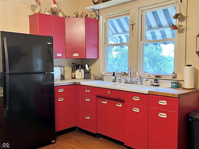 5855 S County Road 800 E, Coatesville, IN 46121 - kitchen with red cabinetry, freestanding refrigerator, light wood-type flooring, and light countertops