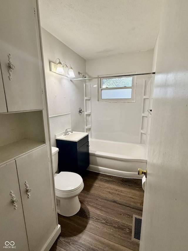 3325 Canaday Dr, Anderson, IN 46013 - full bathroom featuring wood finished floors, toilet, vanity, shower / bathtub combination, and a textured ceiling