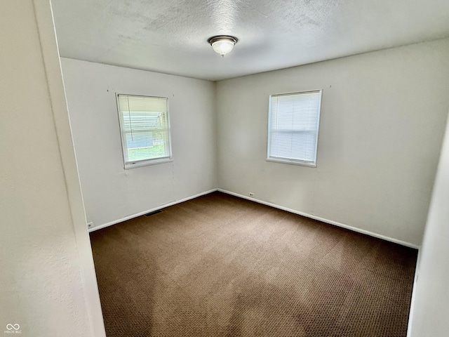 3325 Canaday Dr, Anderson, IN 46013 - spare room with dark colored carpet, baseboards, and a textured ceiling